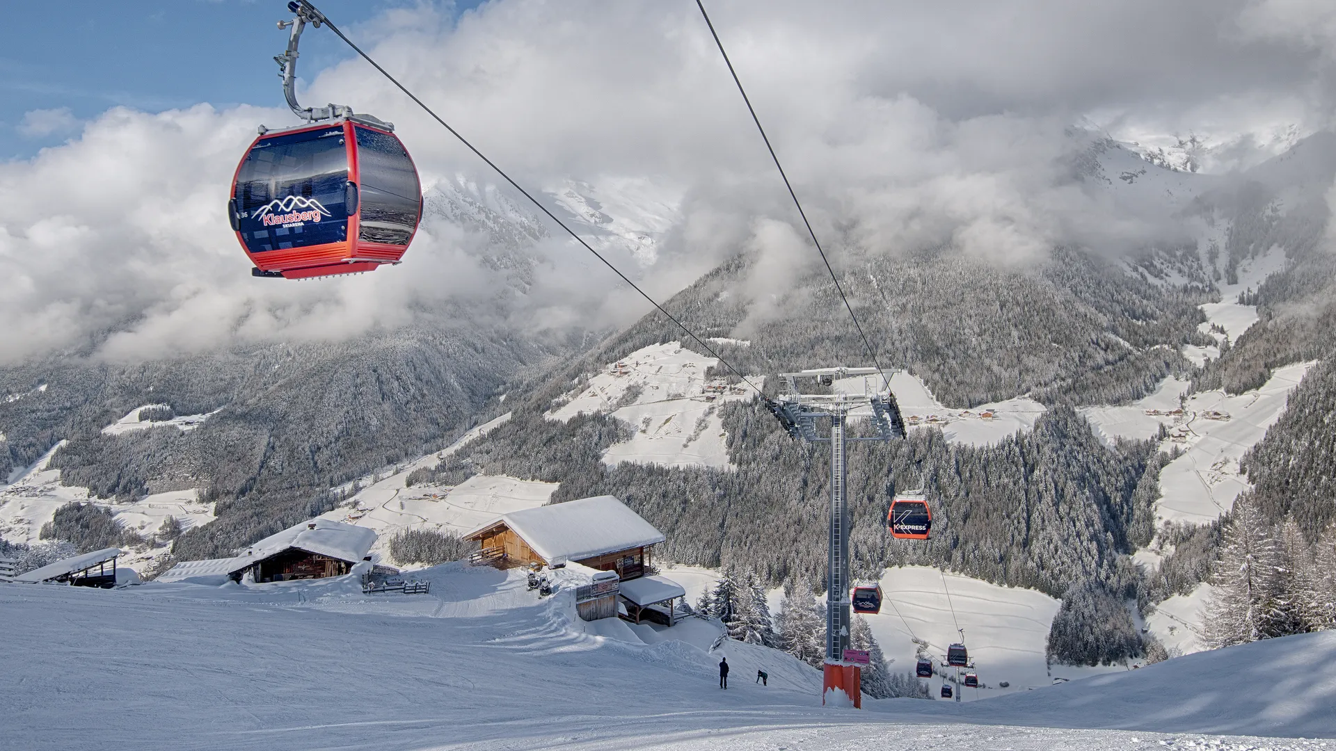 Skifahrer beim dynamischen Carvingschwung auf der Klausberg-Piste, Zillertaler Alpen im Hintergrund