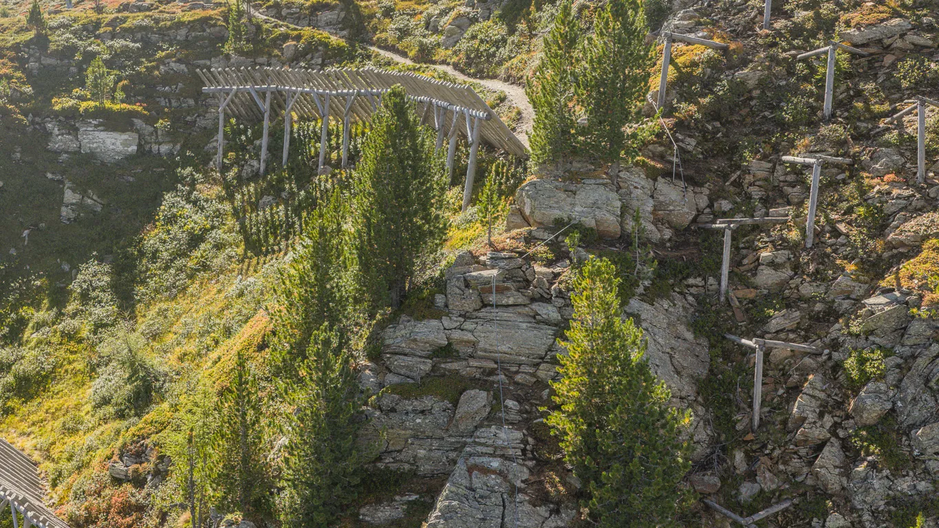 Panoramic view of Ahrntal via ferrata with climber, cable car mountain station and autumn alpine landscape