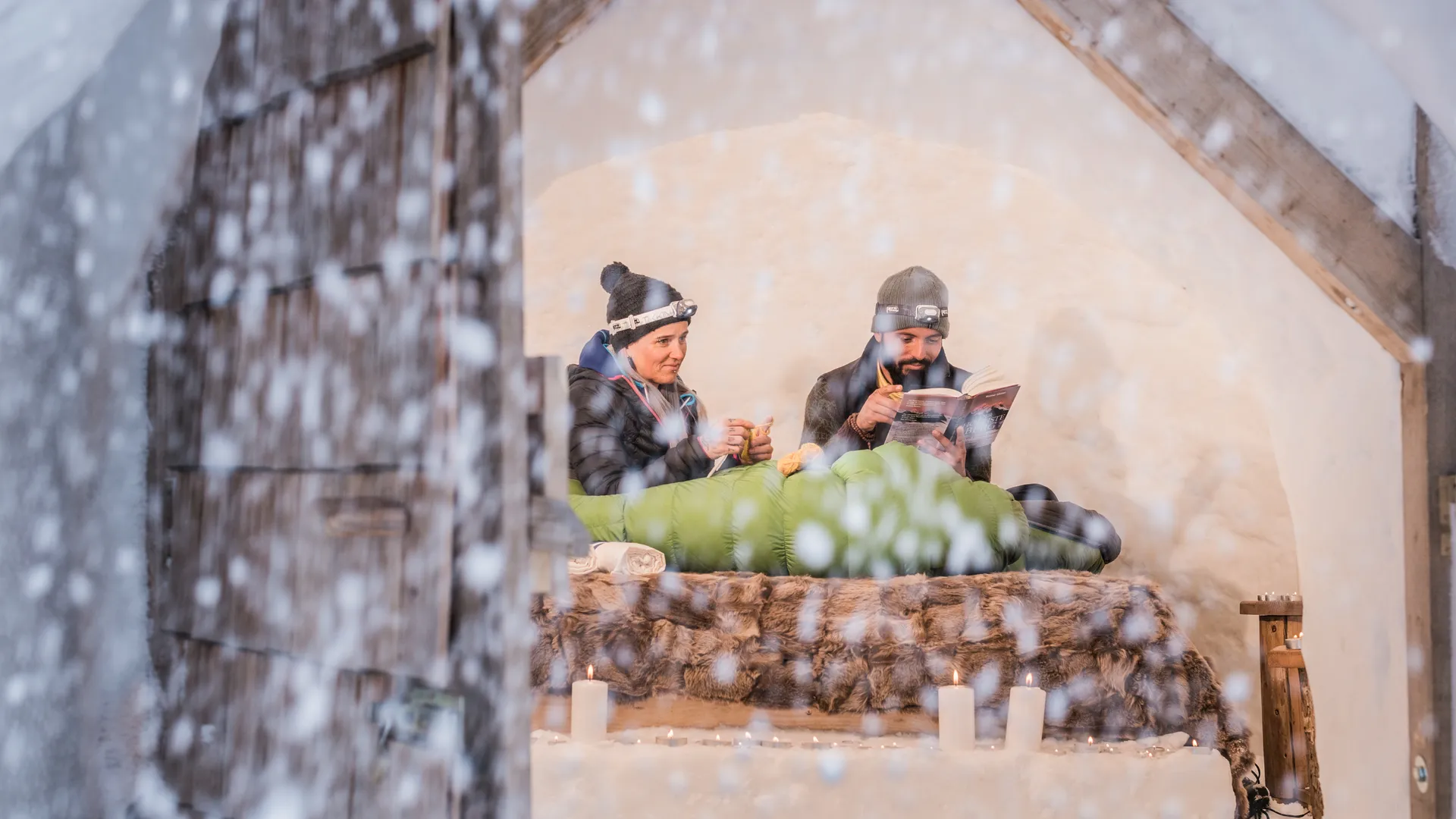 Romantica notte in igloo nella Valle Aurina – coppia in un igloo di neve con candele e lampade frontali