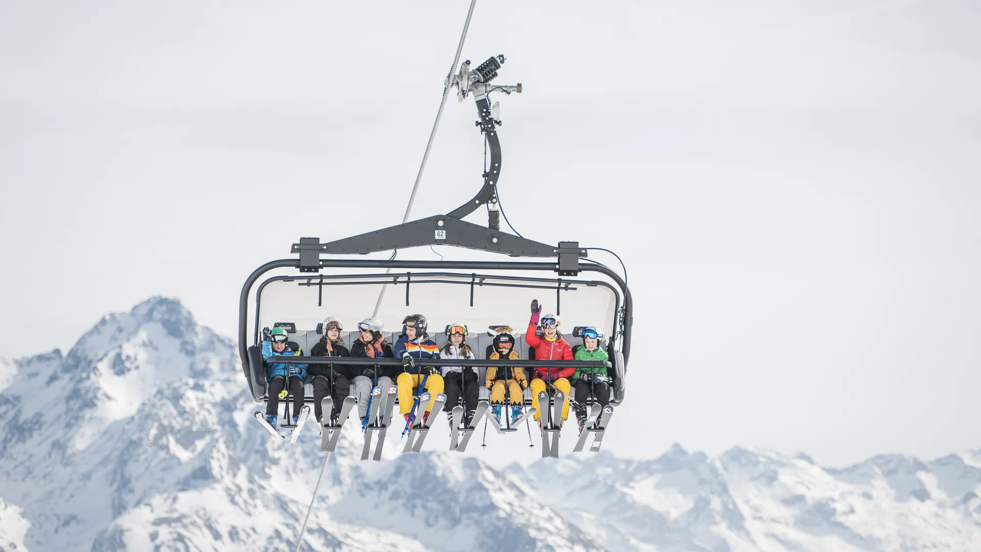 Besetzter Sessellift mit Kindern und Jugendlichen vor Bergpanorama – Liftfahrt im Skigebiet Ahrntal