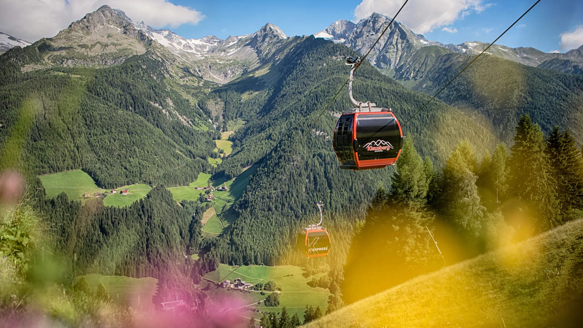 Klausberg Express gondola over green Ahrntal valley with Zillertal Alps in summer