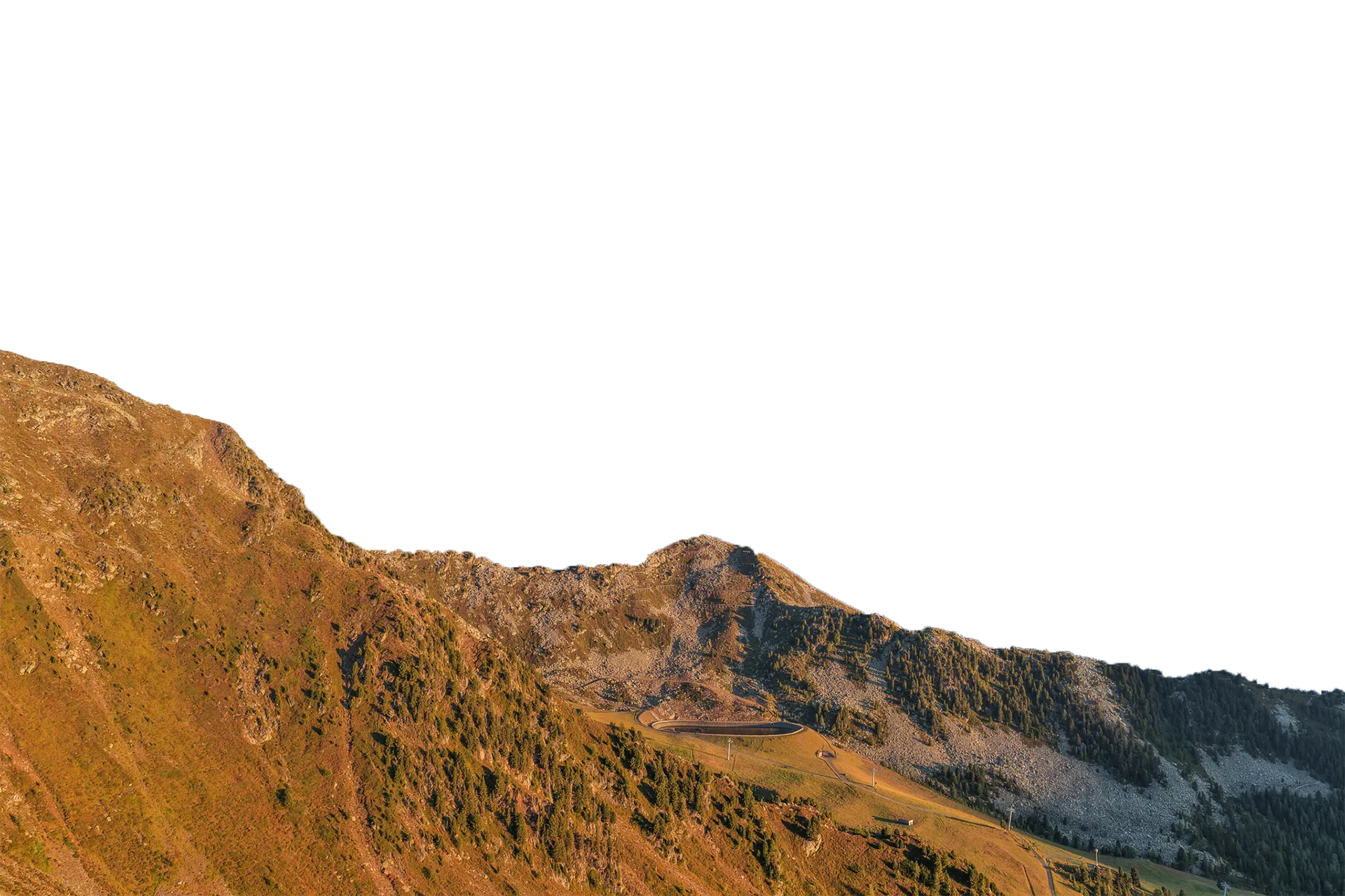 Speikboden mountain ridge in warm evening light with oval snowmaking reservoir
