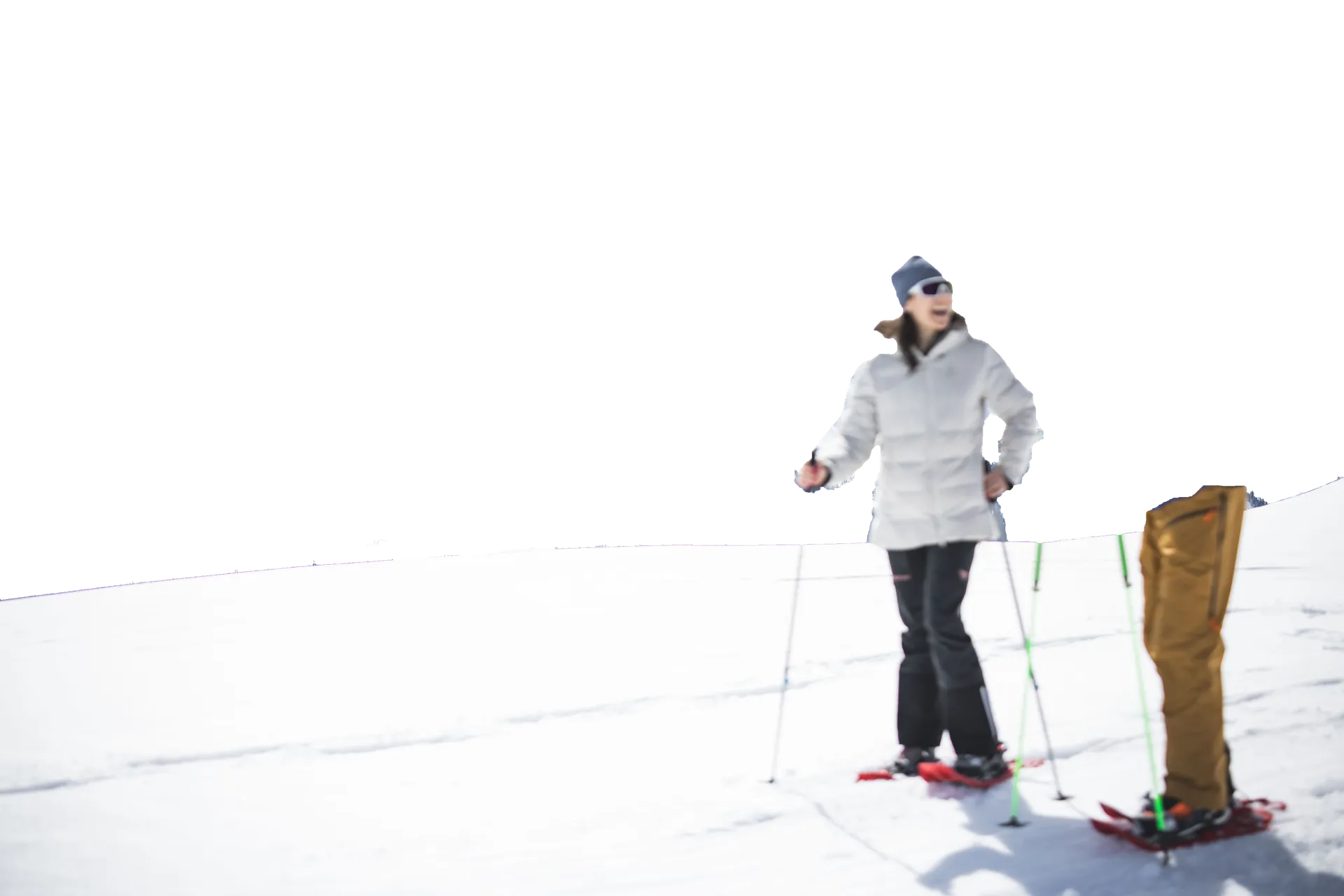Escursionista sorridente con ciaspolette in giacca bianca su neve soleggiata in Valle Aurina