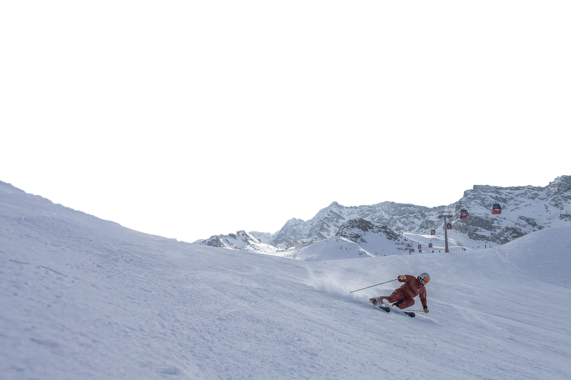 Skier in red outfit carving down the groomed slope on Klausberg with the cable car in the background