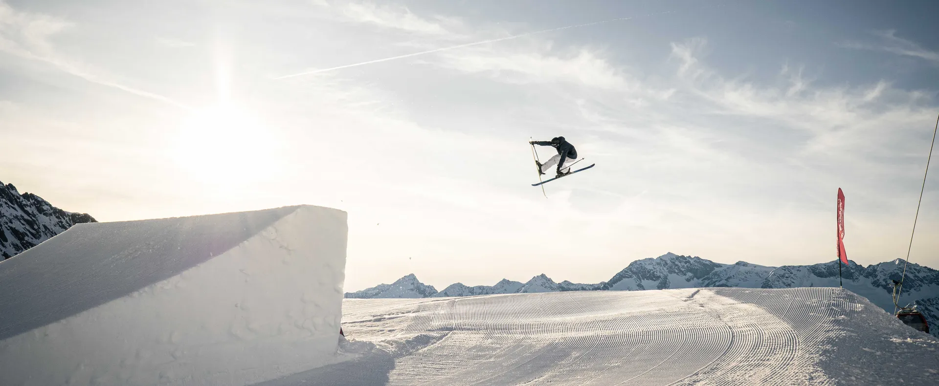 Sciatore freestyle con grab trick nello snowpark Klausberg durante la luce dorata del tramonto