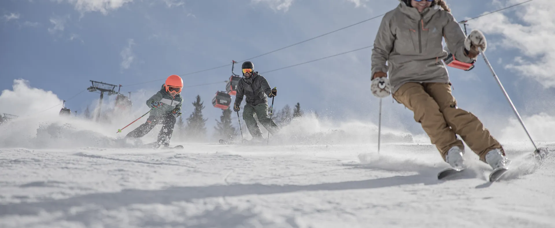 Family with child skiing on a sunny piste at Klausberg under a blue sky