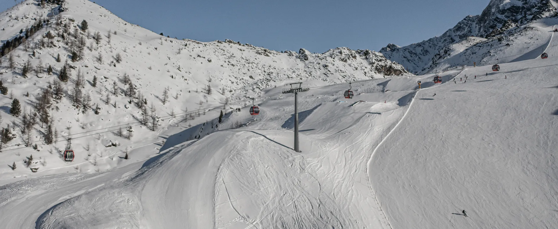 View of the groomed slopes at Klausberg with red gondolas and snow cannons in Ahrntal