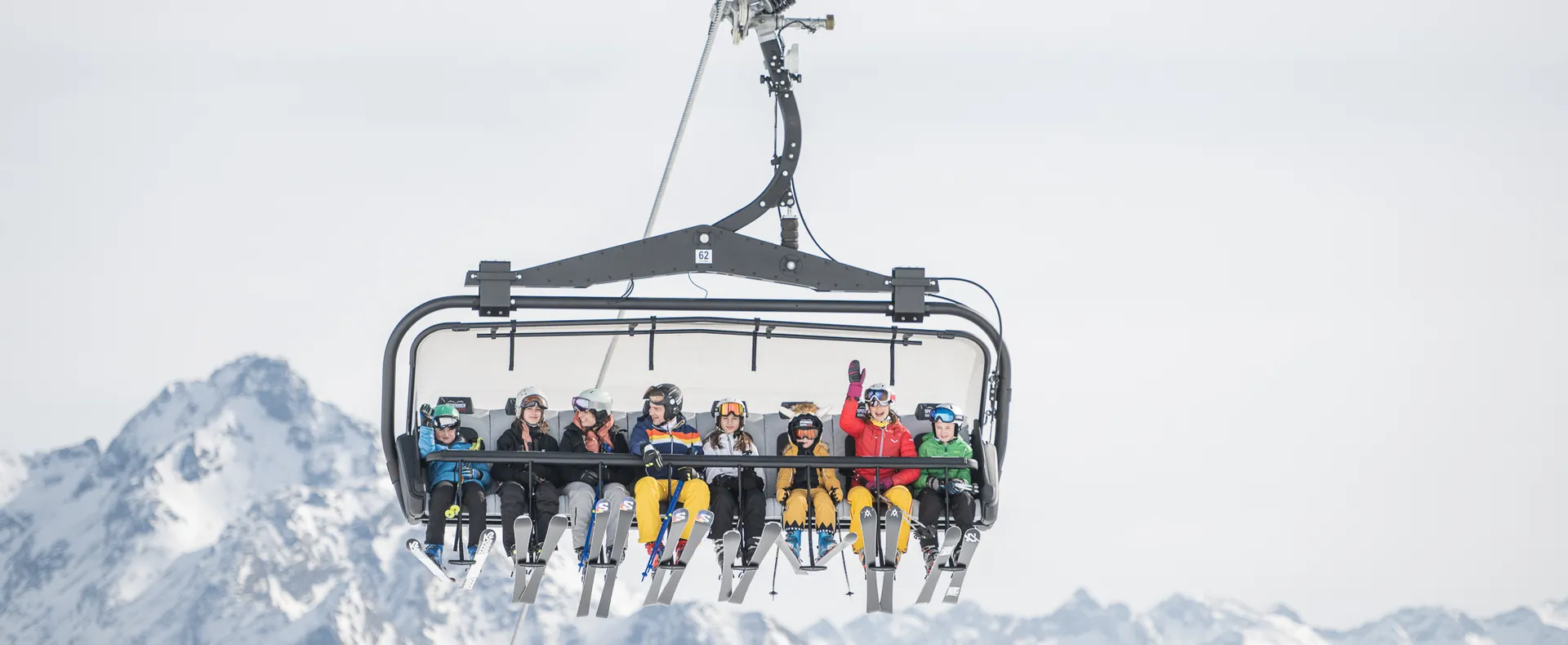 Besetzter Sessellift mit Kindern und Jugendlichen vor Bergpanorama – Liftfahrt im Skigebiet Ahrntal