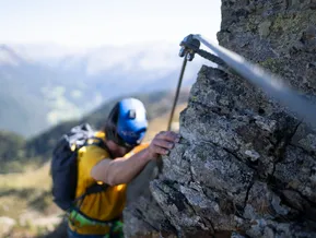 Arrampicatore sulla roccia del via ferrata Speikboden con vista sulla Valle Aurina