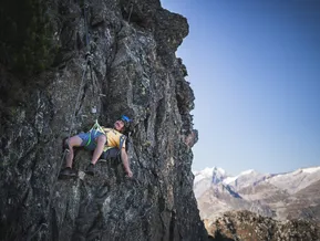 Arrampicatore al via ferrata Speikboden sorride con le Alpi della Zillertal sullo sfondo
