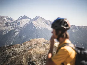 Alpinista allo Speikboden osserva le cime e gli impianti di risalita in estate
