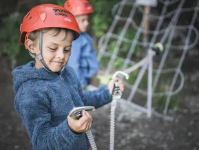 Child at Speikboden via ferrata clipping carabiner onto steel safety cable