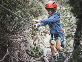 Child in climbing harness on Speikboden adventure via ferrata route in summer