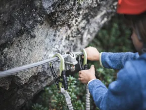 Child clipping via ferrata carabiner onto safety cable at Speikboden