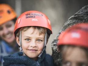 Smiling boy wearing Speikboden Skiworld Ahrntal via ferrata climbing helmet