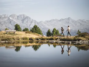 Wanderpaar am Bergsee am Speikboden mit Spiegelung und Panorama der Zillertaler Alpen