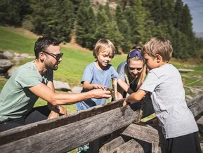 Familie erkundet gemeinsam Naturstation am Erlebnisberg im Ahrntal