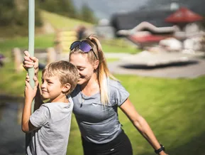 Kind und Begleitperson am Sommerspielplatz der Bergstation Speikboden