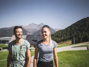 Lachendes Wanderpaar im Sommer am Klausberg mit Bergpanorama im Hintergrund