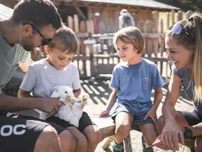 Kinder streicheln weißes Kaninchen am Streichelzoo im Familienpark Klausberg, Ahrntal Südtirol