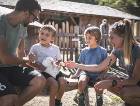 Familie streichelt Kaninchen im Tiergehege am Klausberg im Ahrntal