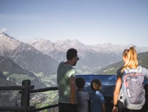 Familie am Aussichtspunkt mit Panoramatafel und Blick auf das Ahrntal und die Zillertaler Alpen
