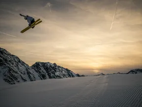 Freestyle-Skifahrer beim Big-Air-Sprung auf Armada-Skiern im goldenen Abendlicht am Klausberg