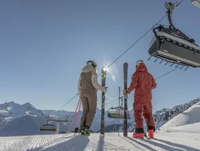 Two skiers at the top station of the chairlift at Speikboden with views of the South Tyrolean Alps