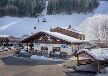 Talstation mit Gondelbahn, Skiverleih und präparierter Piste durch den Nadelwald