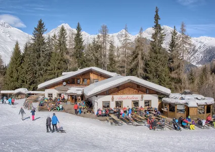 Almboden Skihütte mit belebter Sonnenterrasse und Panorama der Zillertaler Alpen
