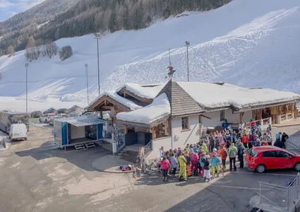 Talstation der Skiworld Ahrntal mit Skischulkindern und verschneiter Bergkulisse im Winter
