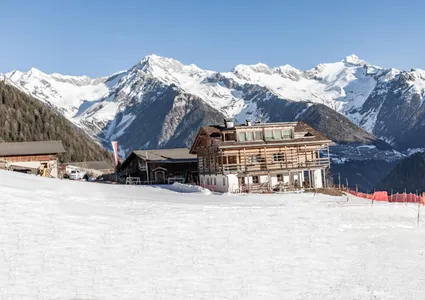 Rustikale Almhütte mit Panorama der Zillertaler Alpen und frisch präparierter Piste