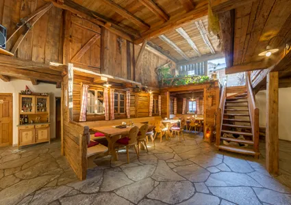 Gemütliche Stube einer Tiroler Almhütte mit Holzvertäfelung und gedeckten Tischen