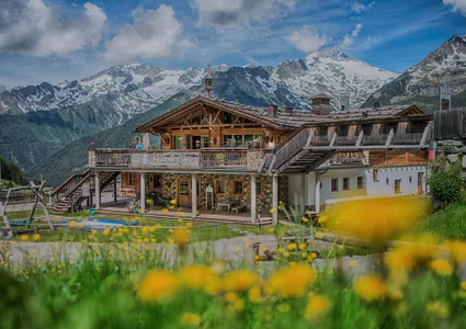 Kristall-Alm am Klausberg mit Holzterrasse und Panoramablick auf die Zillertaler Alpen im Sommer