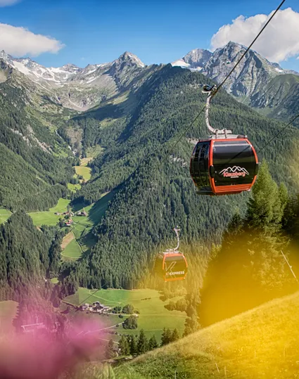 Klausberg Express Gondelbahn über dem grünen Ahrntal mit Zillertaler Alpen im Sommer