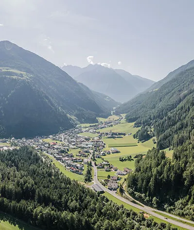 Luftaufnahme Ahrntal im Sommer mit sattgrünen Wiesen, Dorf und Nadelwäldern im Talkessel
