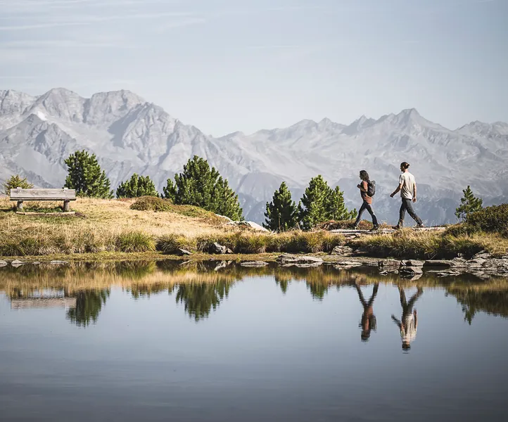 Wanderpaar am Bergsee am Speikboden mit Spiegelung und Panorama der Zillertaler Alpen