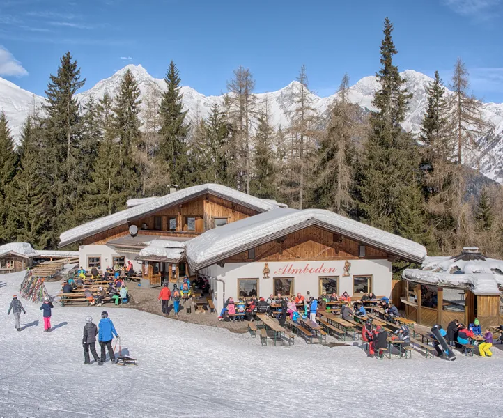 Almboden Skihütte mit belebter Sonnenterrasse und Panorama der Zillertaler Alpen