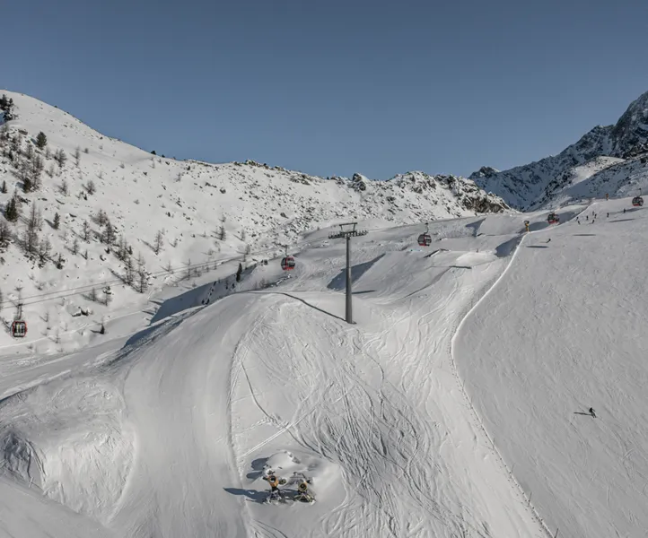 Blick auf die präparierten Pisten am Klausberg mit roten Gondeln und Schneekanonen im Ahrntal