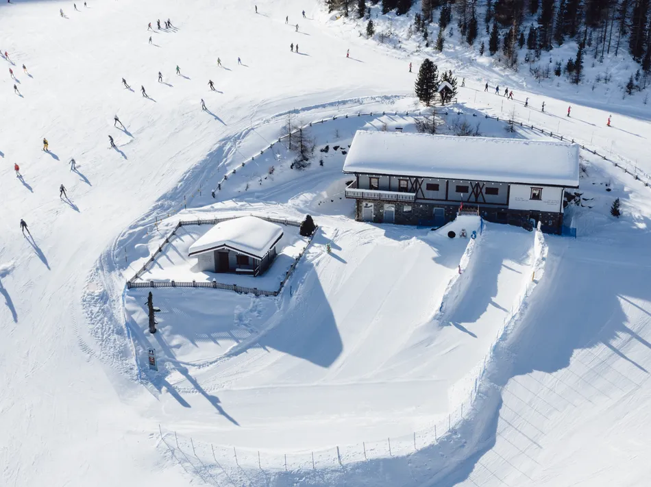 Vista aerea del rifugio sciistico al Klausberg con sciatori sulla pista invernale
