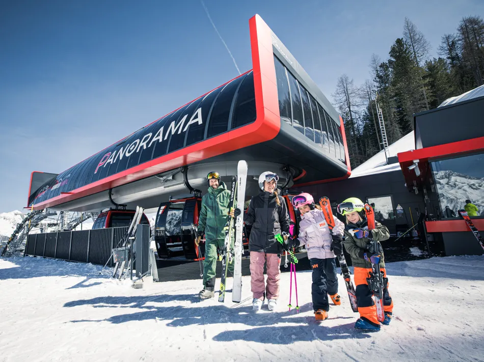 Family in ski gear in front of the modern Panorama mountain station at Klausberg in Ahrntal