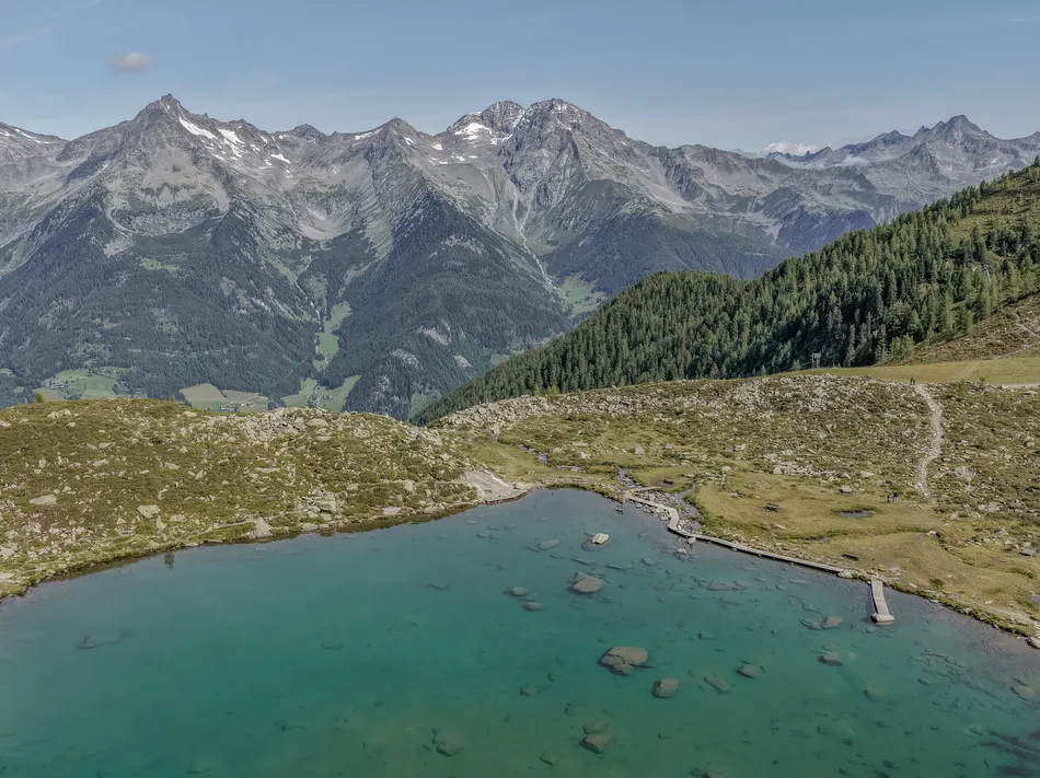 Turquoise mountain lake at Speikboden with panoramic view of the Zillertal Alps