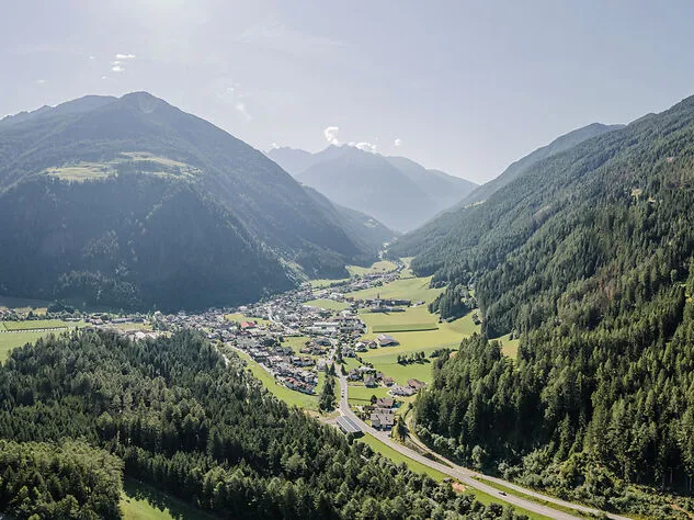Luftaufnahme Ahrntal im Sommer mit sattgrünen Wiesen, Dorf und Nadelwäldern im Talkessel