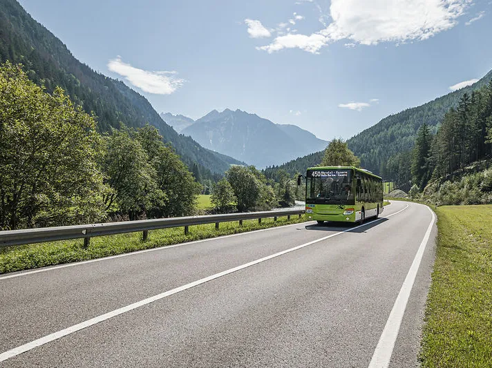Südtiroler Linienbus Linie 450 Ahrntal–Kasern im grünen Sommertal vor Bergkulisse